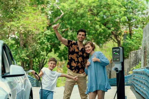 Family road trip vacation with electric vehicle, lovely family recharge EV car with green and clean energy. Natural and eco friendly car travel for sustainable environment. Perpetual