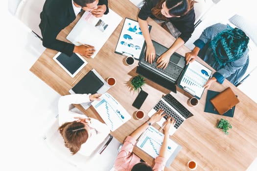 Top view of businessman executive in group meeting with other businessmen and businesswomen in modern office with laptop computer, coffee and document on table. People corporate business team uds