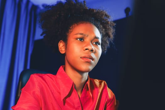 African woman businesswoman or blogger wearing pink shirt with serious face, looking and focusing on screen laptop with struggle project. Concept of stressful expression at work from home. Tastemaker.