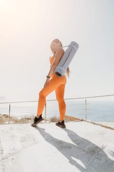 Fitness woman sea. Outdoor workout on yoga mat in park near to ocean beach. Female fitness pilates yoga routine concept. Healthy lifestyle. Happy fit woman exercising with rubber band in park.