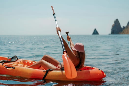 Kayak sea woman. Happy attractive woman with long hair in red swimsuit, swimming on kayak. Summer holiday vacation and travel concept