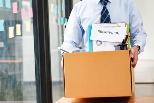 Professional Man Exiting Office with Personal Belongings and Resignation Letter, Embarking on a New Path After Job Resignation