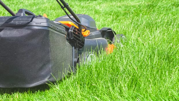 At a residential suburban house, a lush green lawn is meticulously mowed using an electric lawn mower, creating a well-manicured and inviting outdoor space.