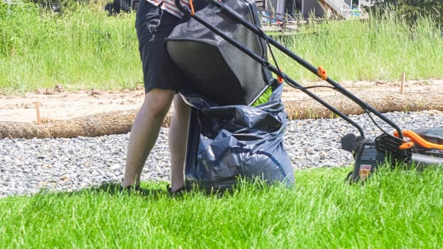 At a residential suburban house, a lush green lawn is meticulously mowed using an electric lawn mower, creating a well-manicured and inviting outdoor space.