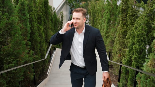 Caucasian businessman walking up stair and calling manager by using smart phone. Top view of manager talking marketing team and planning financial strategy by telephone while going up stair. Urbane.