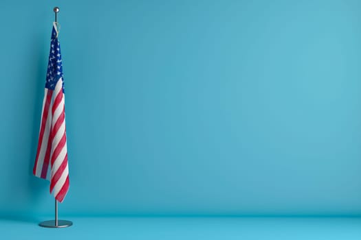 An American flag waving on a pole set against a clear blue sky, symbolizing national pride and patriotism.