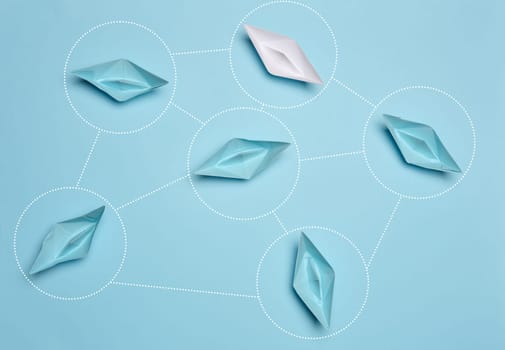 Blue and white paper boats interact with each other, top view