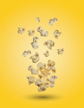 Sweet popcorn on yellow background, grains levitate