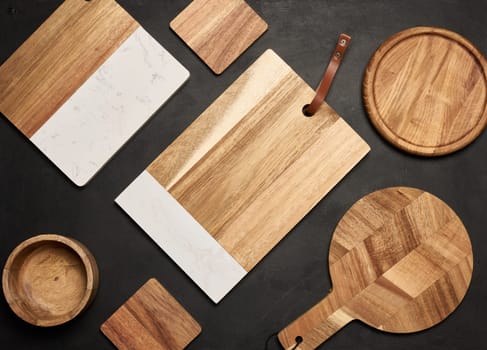 Various wooden cutting boards on a black table, top view