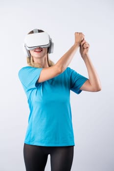 Caucasian girl playing golf and moving gesture by using VR glasses. Happy sport gamer with casual cloth playing game while wearing visual reality headset and standing at pink background. Contraption.