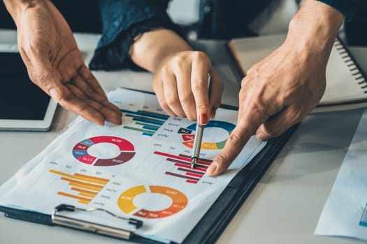 Businessman and businesswoman in meeting working with many financial statement document on desk. Concept of busy business profit analysis and brainstorm. Close up shot at people hands and papers. uds