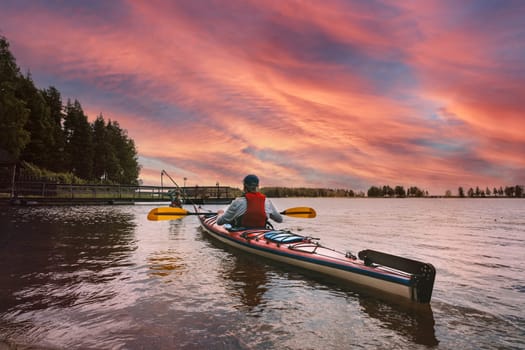 Father and son kayaking together in a lagoon at sunset. Concept: Adventure, Sport, Fun. High quality photo