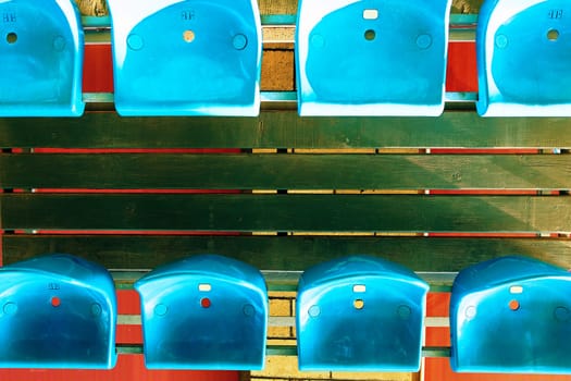Empty plastic seats. Full frame shot of empty blue seats on tribunes.