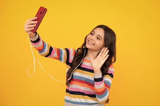 Kids selfie. Portrait of cute teenage girl using mobile phone, chatting on web, typing sms message. Mobile app for smartphone. Happy teenager, positive and smiling emotions of teen girl