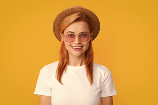 Portrait of funny woman in stylish sunglasses and straw hat on yellow background