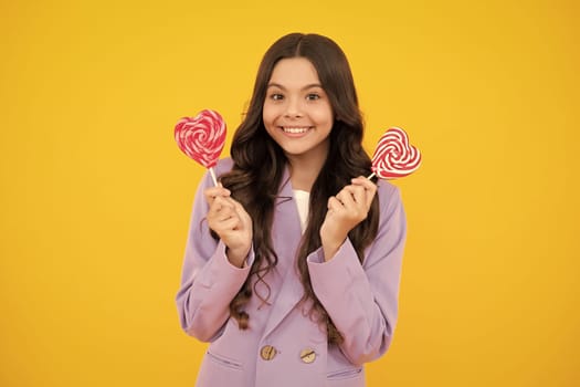 Cool teen child with lollipop over yellow isolated background. Sweet childhood life. Teen girl with yummy lollipop candy. Happy teenager, positive and smiling emotions of teen girl