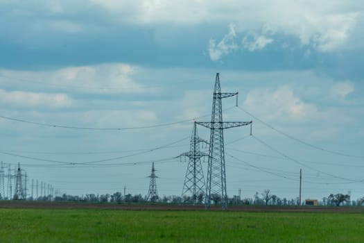 High voltage towers with sky background. Power line support with wires for electricity transmission. High voltage grid tower with wire cable at distribution station. Energy industry, energy saving.