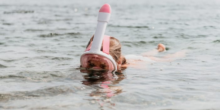 Young happy woman in white bikini put pink snorkeling mask on beach before swimming. girl having fun relaxing on beautiful beach. Beach lifestyle