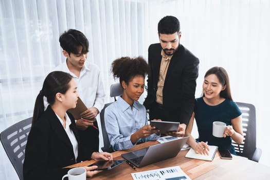 Happy diverse business people work together, discussing in corporate office. Professional and diversity teamwork discuss business plan on desk with laptop. Modern multicultural office worker. Concord