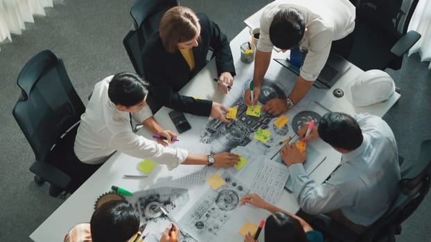 Top view of professional engineer showing and talking about turbine engine design. Aerial view of skilled designer or technician group explain about electronic generator construction. Alimentation.