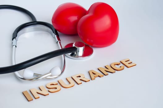 Doctor stethoscopes and heart shape on white background with Insurance text.