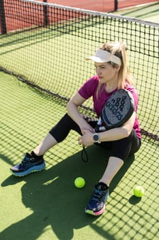 Ukraine Kyiv, March 31 2024. A girl in sportswear is training on a paddle tennis court. Concept of women playing paddle. High quality photo