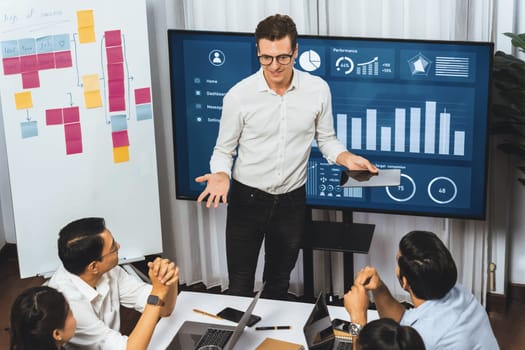 Presentation in office or meeting room with analyst team utilizing BI Fintech to analyze financial data. Businesspeople analyzing BI dashboard power display on TV screen for strategic planning.Prudent