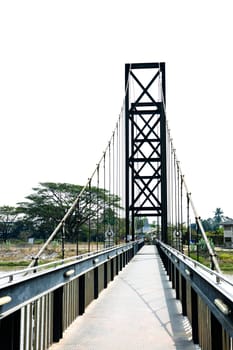 Little Road through metal bridge tunnel over river.