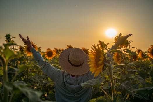 A woman in a straw hat is holding a sunflower. Concept of warmth and happiness, as the woman is surrounded by the bright and cheerful flower