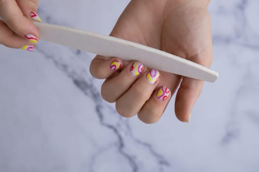Manicure tools Pastel softness colorful manicured nails. Woman showing her new summer manicure in colors of pastel palette. Simplicity decor fresh spring vibes earth-colored neutral tones design