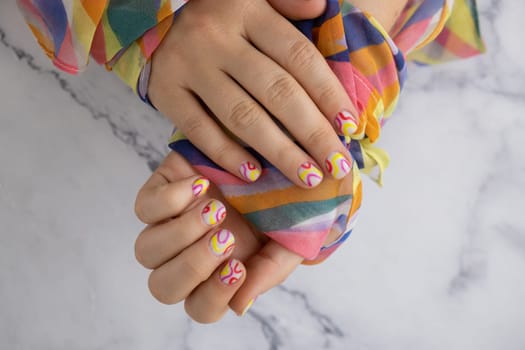 Pastel softness colorful manicured nails. Woman showing her new summer manicure in colors of pastel palette. Simplicity decor fresh spring vibes earth-colored neutral tones design