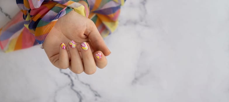 Woman manicured hands, stylish summer colorful nails. Closeup of manicured nails of female hand. Summer style of nail design concept. Beauty treatment.