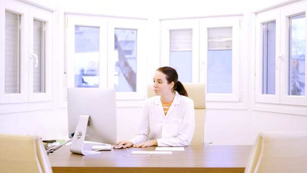 Female doctor in the office using computer in a medical clinic