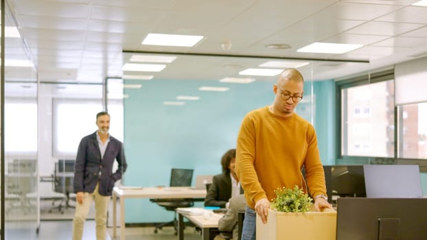 Hispanic man collects his belongings from an office after being fired