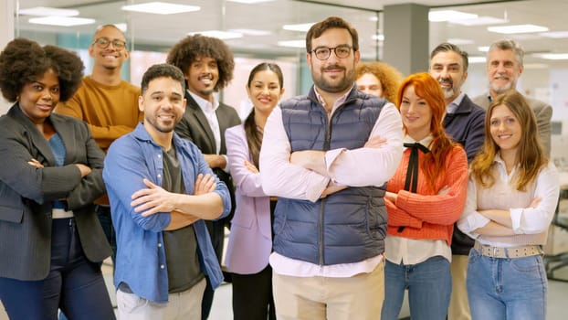 Work team of a coworking with boss leading them smiling at camera