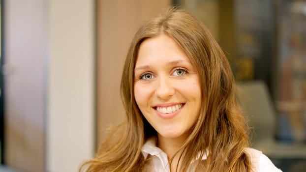 A young female coworker smiling at camera in the office