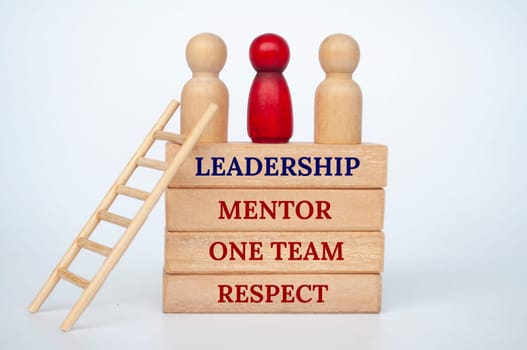 Leadership concept with doll figures on top of wooden blocks with wooden ladder.