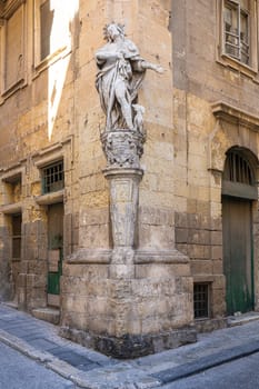 Valletta, Malta, April 03, 2024.  the typical religious statues at the corners of the ancient buildings and the city centre