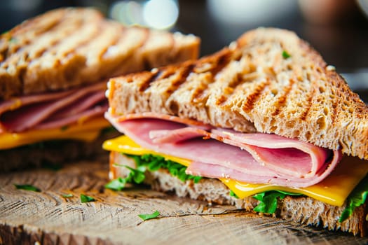 Close-up view of grilled ham and cheese sandwich halves on wooden surface