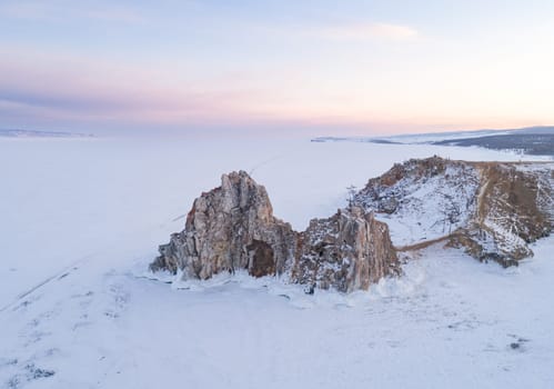 Aerial shot of a Shamanka rock on Olkhon island at sunset. Winter landscape. Popular touristic destination. Natural landmark. Panoramic view.