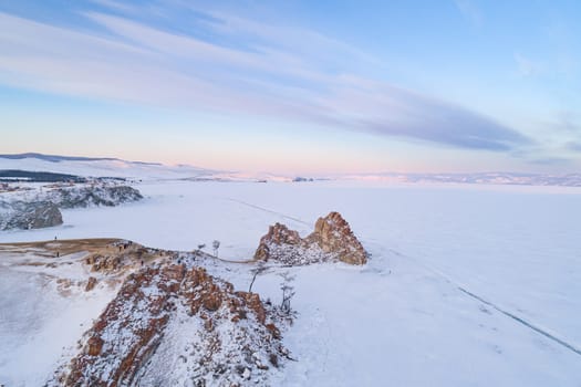 Aerial shot of a Shamanka rock on Olkhon island at sunset. Winter landscape. Popular touristic destination. Natural landmark. Panoramic view.