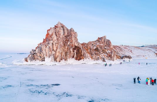 Aerial shot of a Shamanka rock on Olkhon island at sunset. Winter landscape. Popular touristic destination. Natural landmark. Panoramic view.