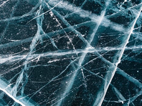 Aerial top down view on the blue cracked ice of the lake Baikal. Winter landscape, frozen lake. Ice kingdom.