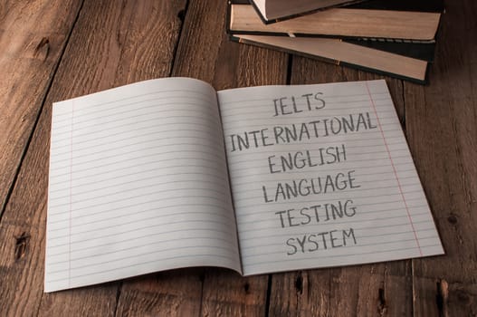 A notebook is open to a page with the words Ielts International English Language Testing System" written on it