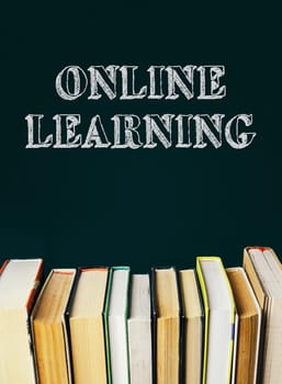 A stack of books with the words Online Learning written on top. The books are arranged in a row, with some of them being larger than others. Concept of education and learning