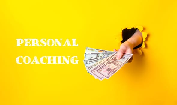 A person is holding a bunch of money and the words Personal Coaching are written below them
