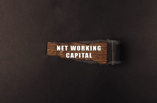 A wooden object with the words Networking Capital written on it. The image has a dark background and the words are in white