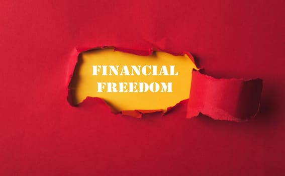 A red background with a hole in it and the words financial freedom written in white. Concept of openness and possibility