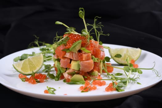 Avocado tartare with salmon, red caviar and pea sprouts.