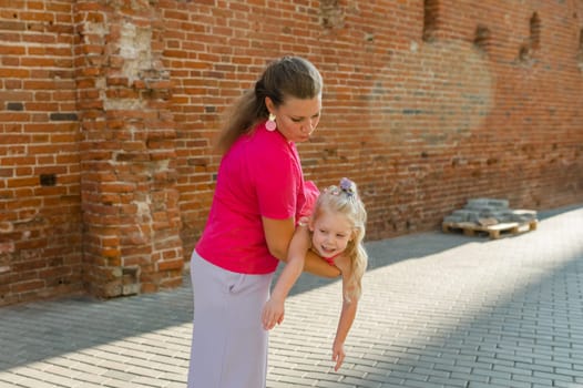 Child girl with cochlear implant with her mother spend time outdoor. Hear impairment and deaf community concept. Deaf and health concept. Diversity and inclusion. Copy space.